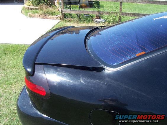 Black aftermarket rear spoiler mounted on a car's trunk lid