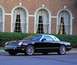 2002 Ford Thunderbird - Black 2002 Ford Thunderbird convertible with a white hardtop sits in front of a brick building.