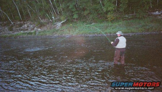 Man fishing in a river with a fly rod