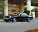 2002 Ford Thunderbird - A woman loads shopping bags into the trunk of a black 2002 Ford Thunderbird convertible with a white hardtop, parked in front of a Neiman M…