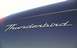 2002 Ford Thunderbird - Close-up of the 'Thunderbird' emblem on the rear quarter panel of a dark blue 2002 Ford Thunderbird.