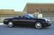 2002 Ford Thunderbird - A woman stands by a black 2002 Ford Thunderbird convertible outside a Neiman Marcus store.