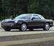 2002 Ford Thunderbird - A black 2002 Ford Thunderbird convertible with a white hardtop is parked on a paved surface.