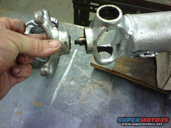 The end mounting bracket has a swivel pressed into it and the hole in the swivel is where the spring on the right goes into.   be careful during disassembly to not loose the spring.  