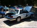 1987 Ford Mustang - A white Ford Mustang, marked as State Patrol, is parked with its hood and trunk open at an outdoor event.