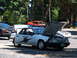1987 Ford Mustang - A white 1987 Ford Mustang police car is parked with its hood open, displaying "STATE PATROL" on the door and blue lights on the roof.