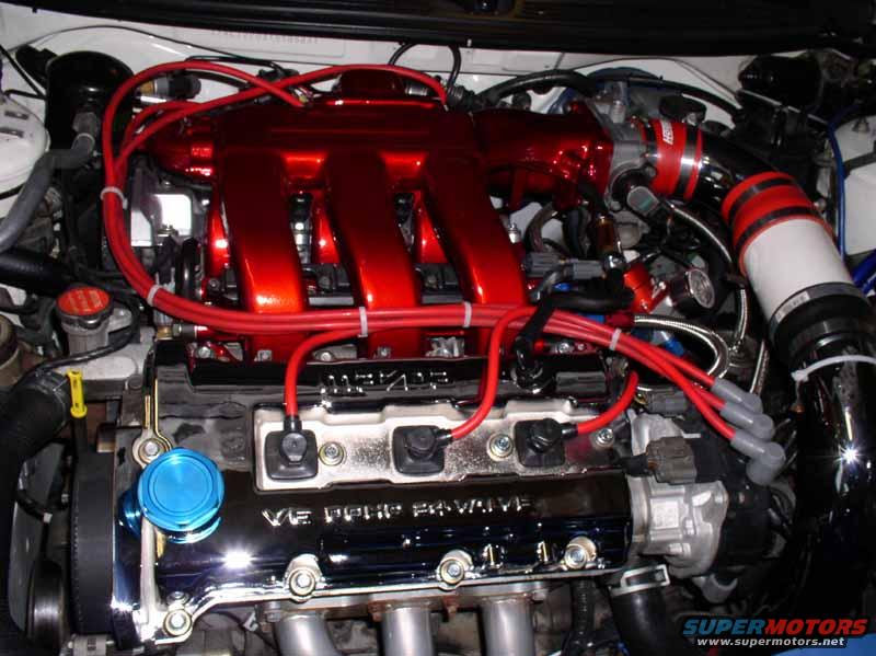 Engine bay with red intake manifold and V6 DOHC valve cover