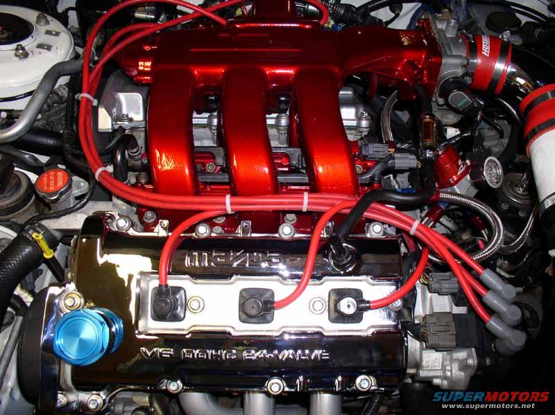Engine bay with red intake manifold and V6 DOHC 24-VALVE engine cover