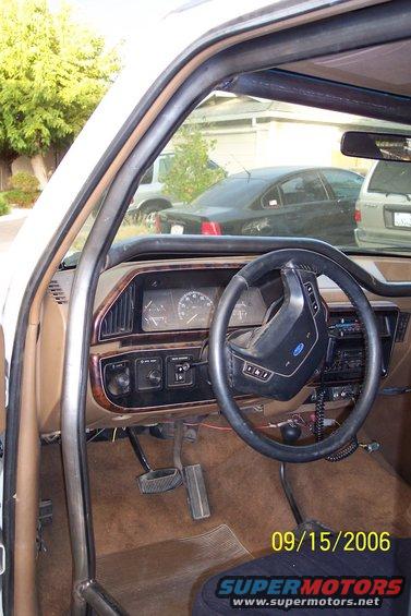 Interior of a white vehicle showing dashboard, steering wheel, and roll cage. Dated 09/15/2006