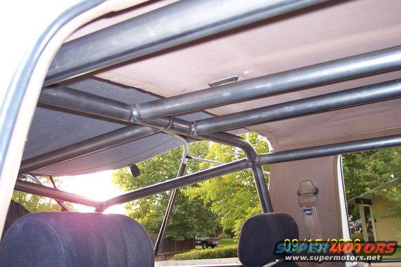Interior roll cage with visible seatbelts and headrests