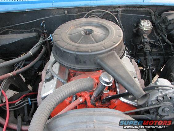 Engine bay with large black air cleaner and orange engine block