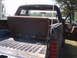 1988 Ford Bronco - The interior of the SUV shows a folded rear seat and the open truck bed, with an antenna visible on the exterior.