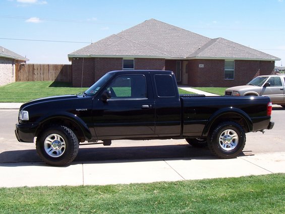 Black 2003 Ford Ranger pickup truck, side view, parked on street