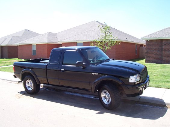 Black 2003 Ford Ranger pickup truck parked on a residential street, three-quarter front view