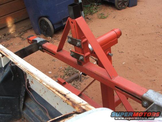 Red engine hoist component attached to a rusty white metal edge