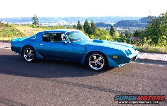 Blue 1979 Pontiac Trans Am parked on the side of a road with a scenic overlook in the background