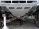 1984 Ford Bronco - The undercarriage of a vehicle is shown, custom skid plates and suspension modifications.