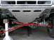 1984 Ford Bronco - The front suspension and skid plate of a modified truck are visible from below.