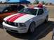 2002 Ford Mustang - White Ford Mustang with red racing stripes parked at a car show.