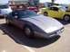 2002 Ford Mustang - A gray Chevrolet Corvette C4 is parked at an outdoor car show with other vehicles visible.