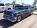2002 Ford Mustang - A classic 1956 Chevrolet Bel Air is displayed at a car show next to a white truck.