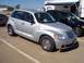 2002 Ford Mustang - A silver Chrysler PT Cruiser is parked in a lot, with other vehicles and an RV in the background.