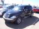 2002 Ford Mustang - A black Chrysler PT Cruiser is parked at an outdoor car show.