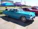 2002 Ford Mustang - A turquoise and white 1958 Ford Thunderbird is parked at a car show next to other vehicles.