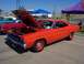 2002 Ford Mustang - A classic orange Plymouth Road Runner is displayed with its hood up at an outdoor car show.