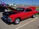 2002 Ford Mustang - A red 1967 Chevrolet Chevelle SS coupe is displayed with its hood and trunk open at a car show.