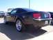 2002 Ford Mustang - Rear view of a black Ford Mustang with custom chrome wheels.