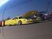 2002 Ford Mustang - A yellow 2000s Ford Mustang is displayed with its hood open at a car show.