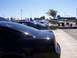 2002 Ford Mustang - A line of black Ford Mustangs are parked at a car show on a sunny day.