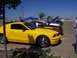 2002 Ford Mustang - Several cars are lined up at an outdoor event, with a yellow Mustang in the foreground.