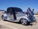 2002 Ford Mustang - A custom hot rod coupe with flame graphics is displayed at a car show with two onlookers.