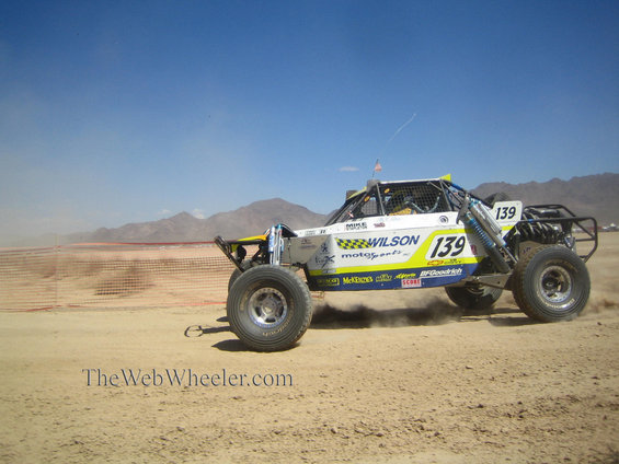 Off-road race truck with number 139 on side, kicking up dust