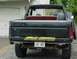 1985 Ford Bronco - Rear view of a black 1985 Ford Bronco pickup truck with a spare tire in the bed.