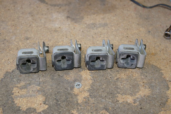 Four metal brackets with rubber inserts, likely for mounting something