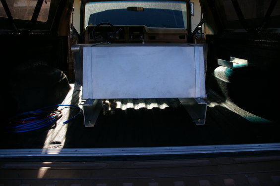Auxiliary fuel tank mounted in the cargo area of a 1980s Ford Bronco, viewed from the rear