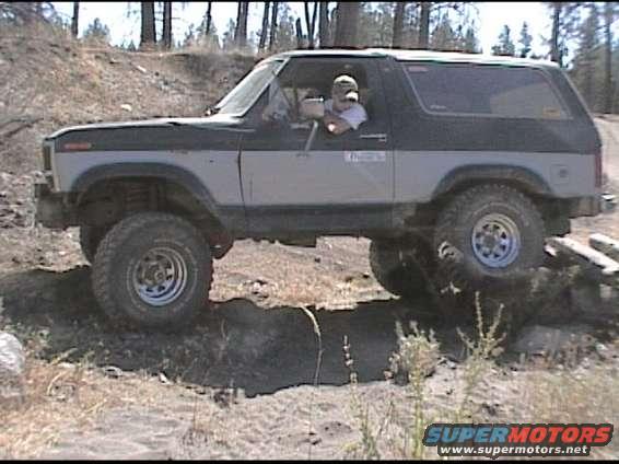 Ford Bronco driving over rough terrain with a person inside