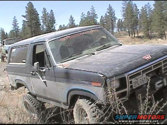 Dark blue and gray Ford Bronco with off-road tires, front 3/4 view