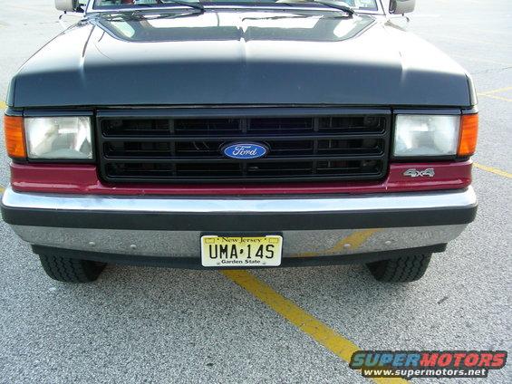 Front view of a 1990 Ford Bronco with a black grille and maroon lower panel