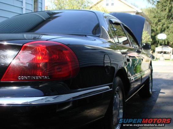 Black Lincoln Continental parked outside with hood up. Rear taillight and "CONTINENTAL" text visible