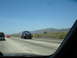 1992 Ford Taurus - A car is being transported on a tow truck along a highway under a clear blue sky.