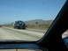 1992 Ford Taurus - A blue sedan is being transported on a tow truck along a highway with mountains in the background.