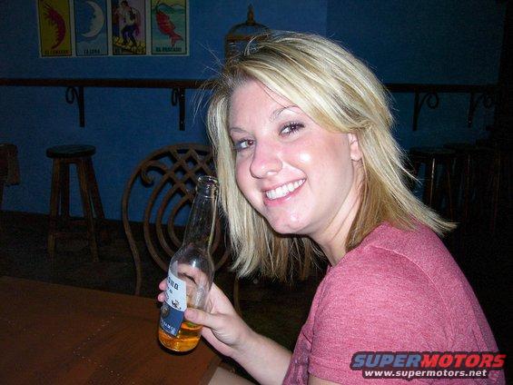 Woman holding a beer bottle in a bar