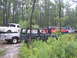1990 Ford Bronco - Several off-road vehicles are gathered in a forest clearing, with one Bronco in the foreground.