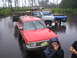 1990 Ford Bronco - Several off-road vehicles are submerged in water, with a red SUV in the foreground.