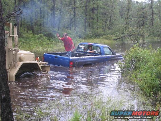 1995 Dodge 1500 stuck in water, being pulled by a military truck