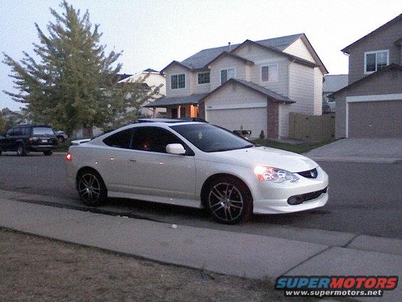 White Acura RSX parked on suburban street, another SUV in background